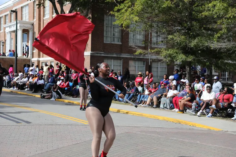 A color guard performer carrying a garnet flag