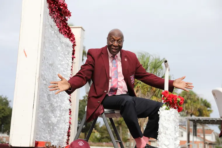 A Homecoming parade participant greeting the crowd from a float